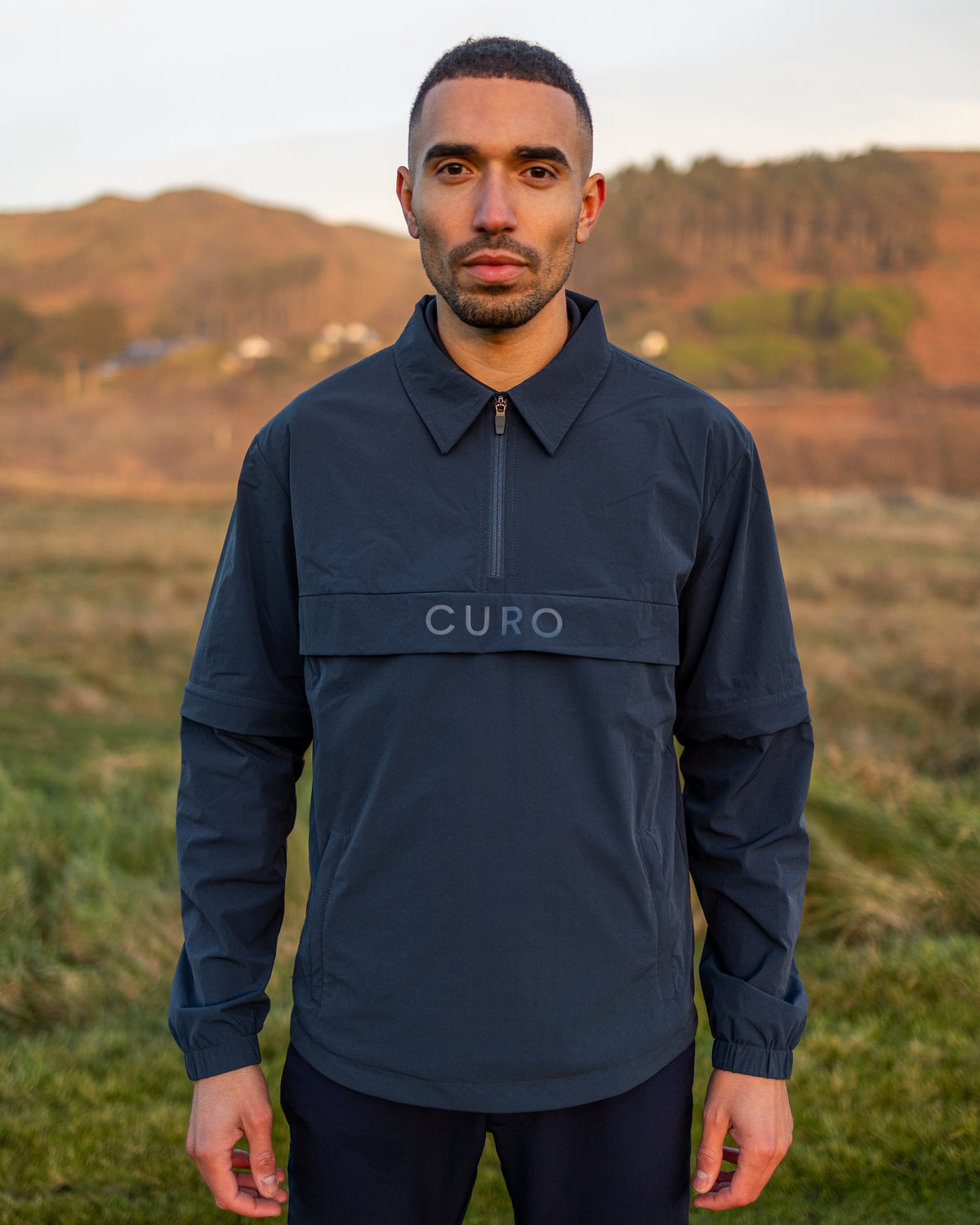 Cadence Windshirt in navy, worn on the course