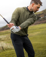 Merino Haven Hoodie in green, mid-swing on the course