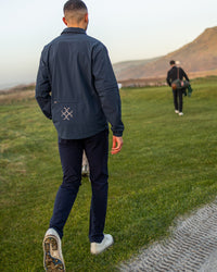 Cadence Windshirt in navy, rear view on the course