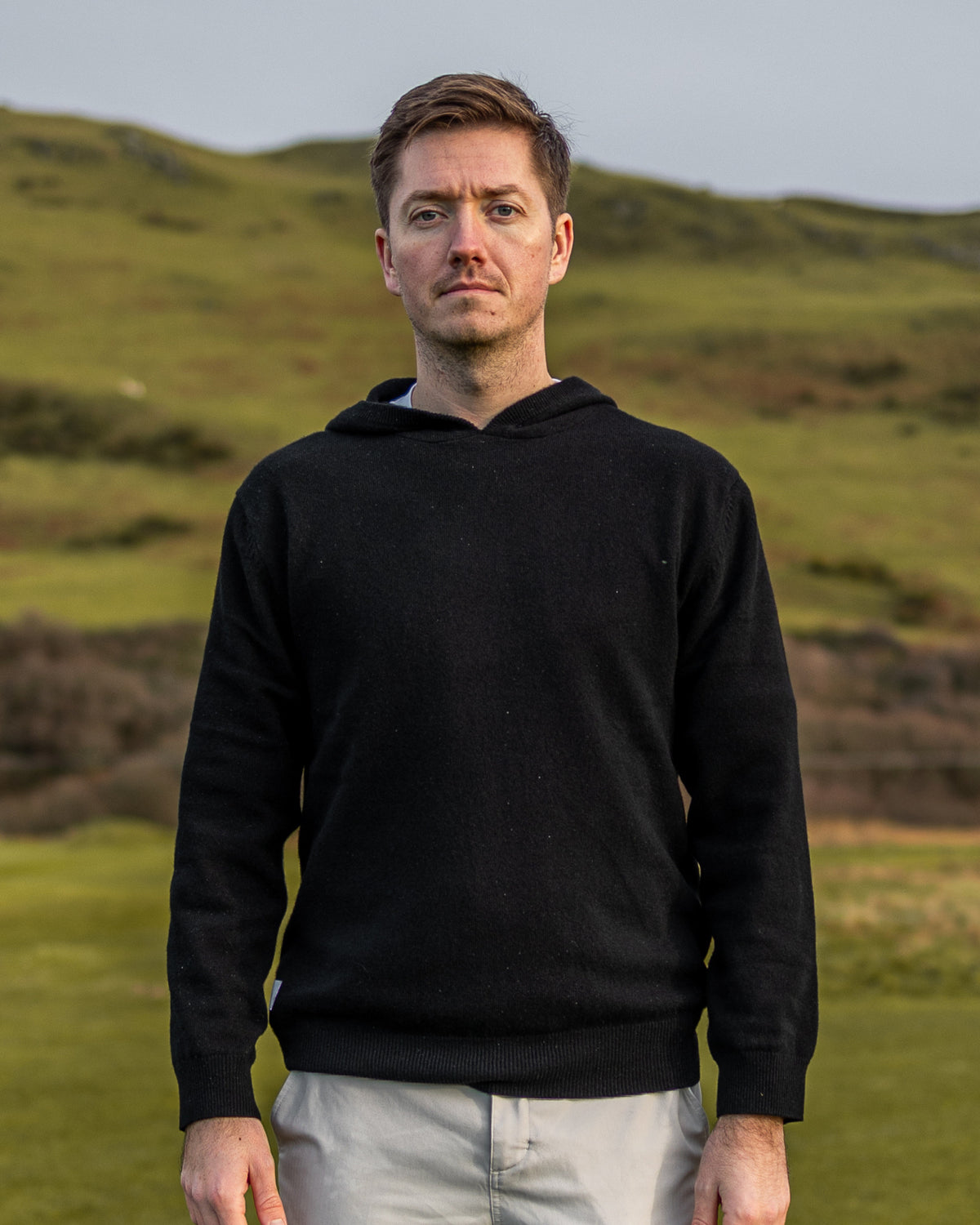 Merino Haven Hoodie in black, worn on the course
