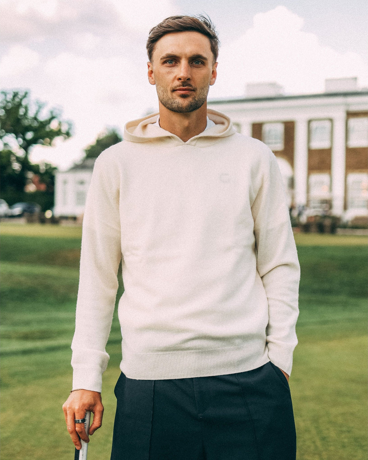 Merino Haven Hoodie in cream, worn at the golf club