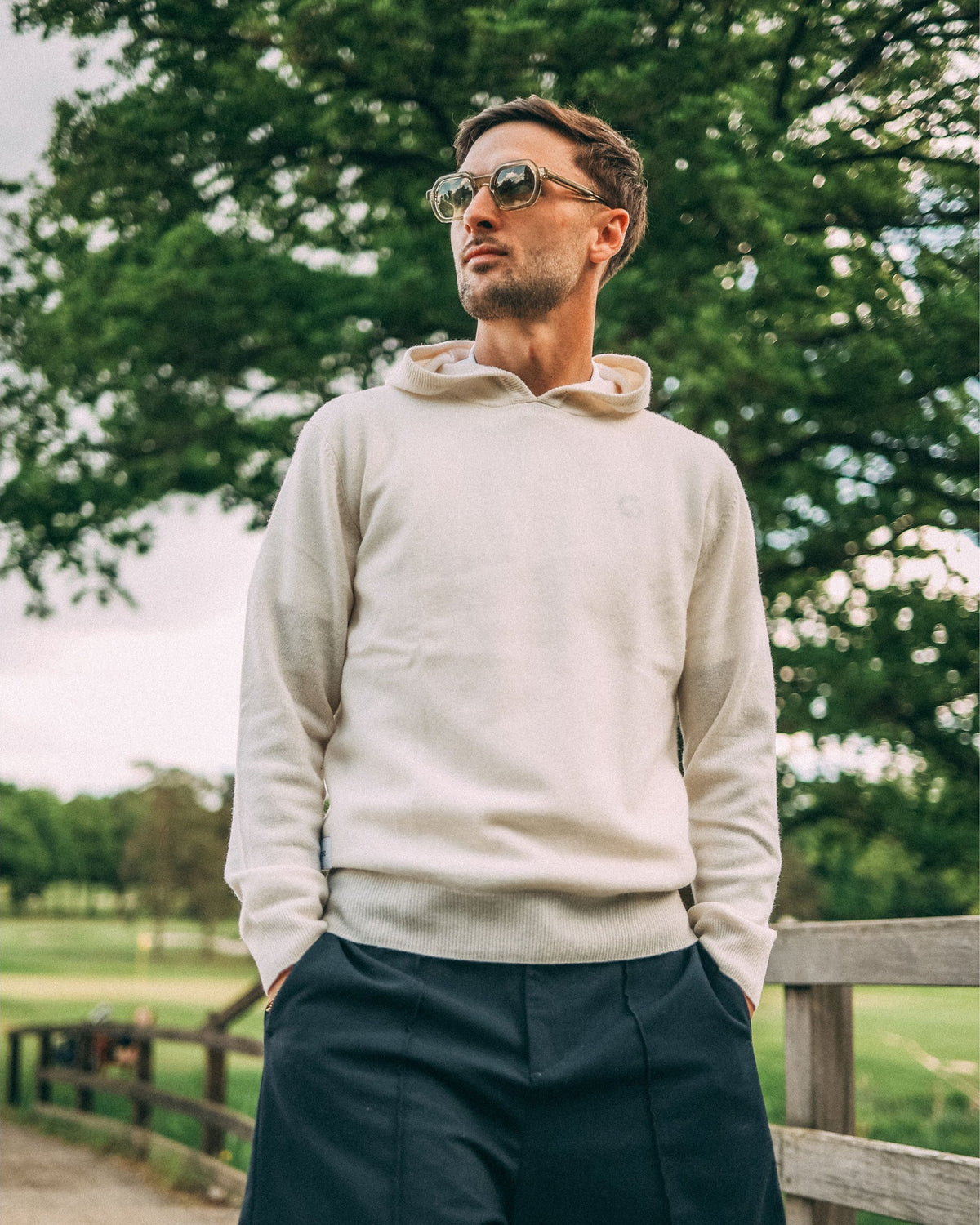 Merino Haven Hoodie in cream, worn on the course
