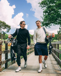 Merino Haven Hoodies in cream and black, walking to the course