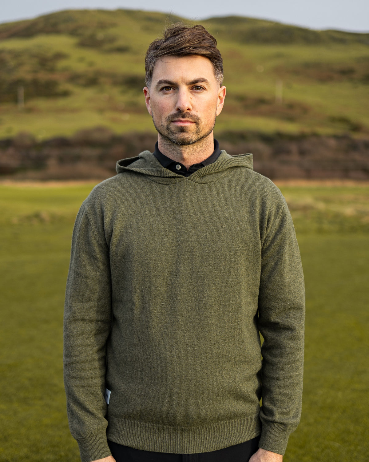 Merino Haven Hoodie in green, worn on the course
