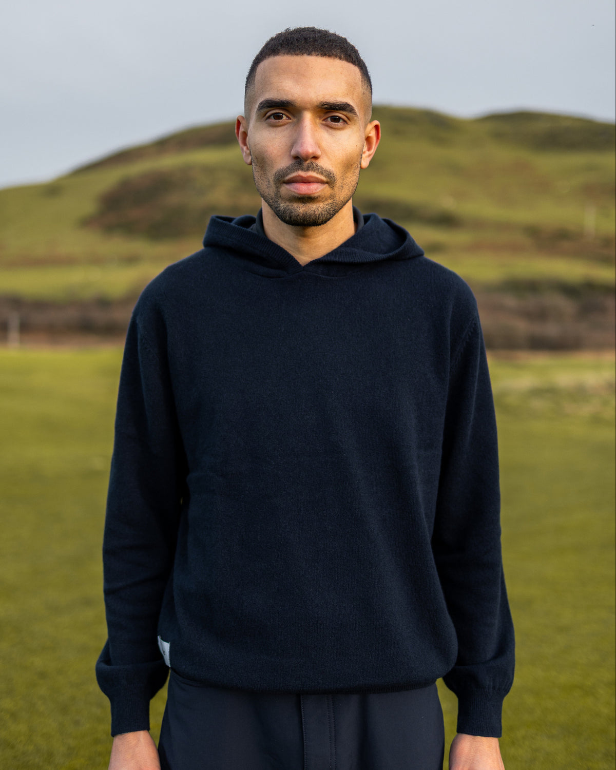 Merino Haven Hoodie in navy, worn on the course