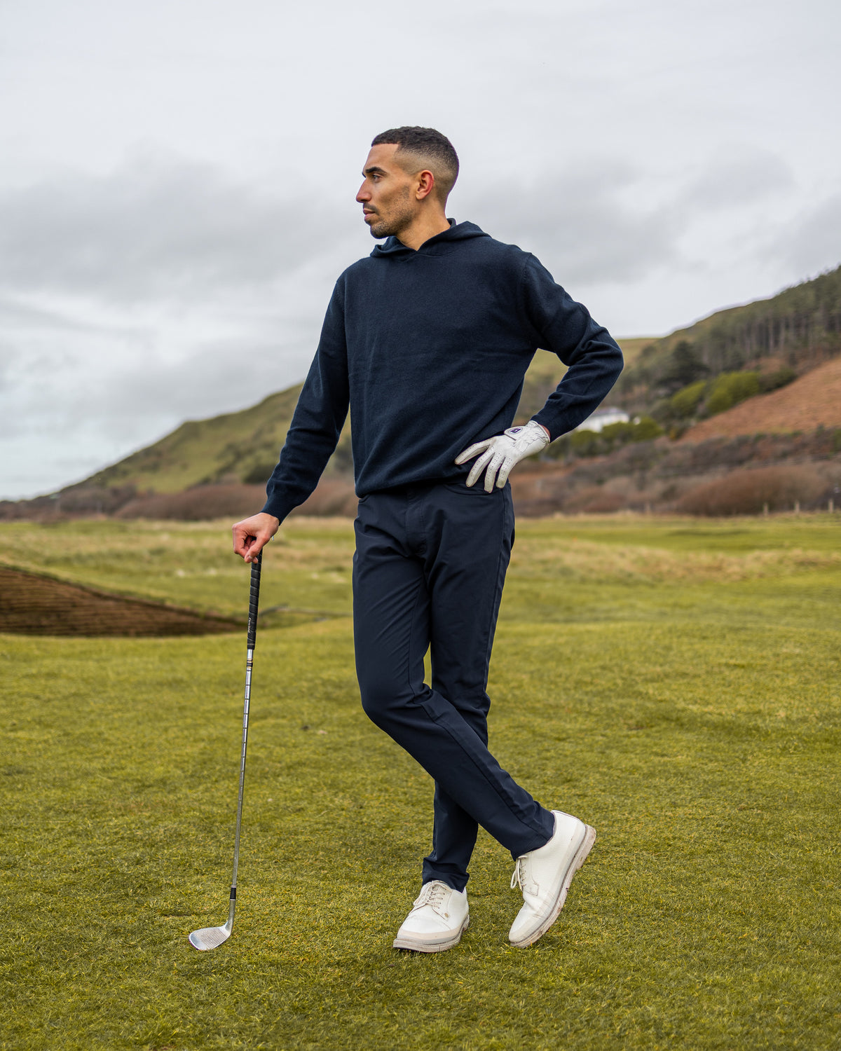 Merino Haven Hoodie in navy, standing on the course