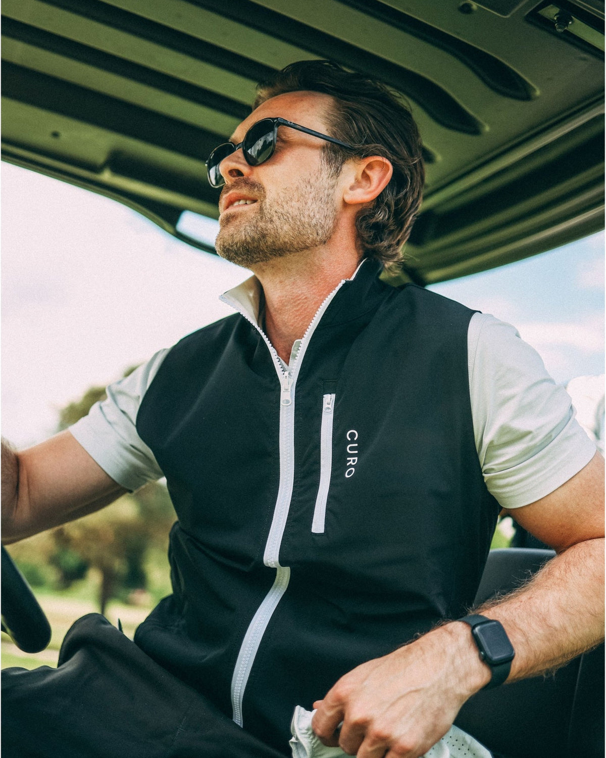 Revere Reversible Gilet in black, worn in a golf buggy